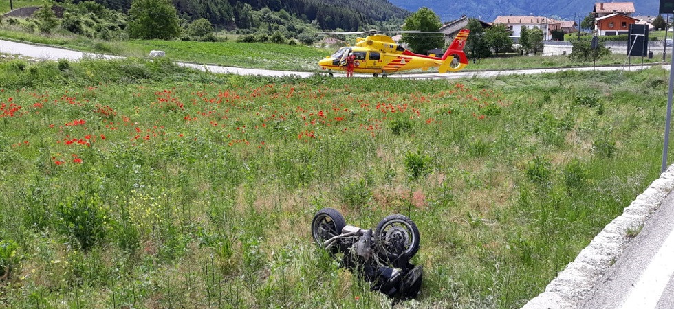 Sbanda in curva e finisce a terra in mezzo alla carreggiata, mentre la moto conclude la corsa in campagna contro alcune rocce