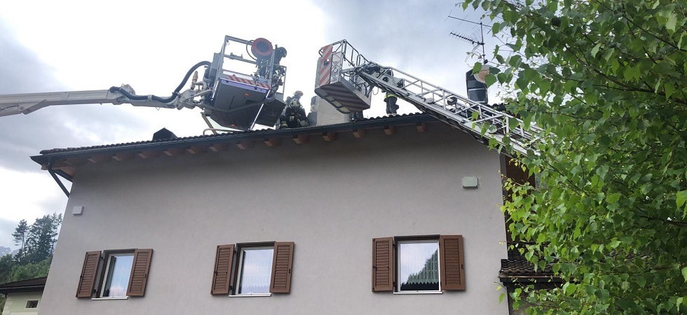 Una colonna di fumo e il fuoco, diversi corpi dei vigili del fuoco per spegnere l'incendio di un tetto