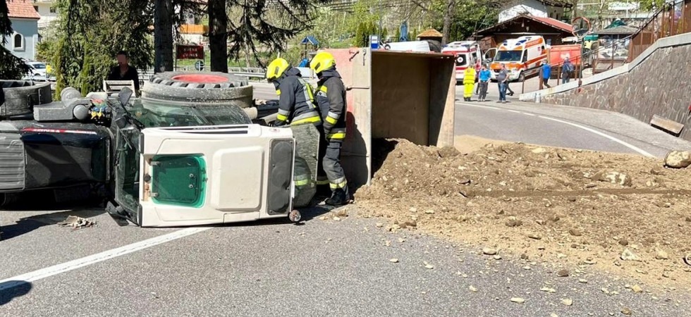 Trattore con rimorchio si ribalta e tutto il materiale finisce sulla strada, vigili del fuoco in azione
