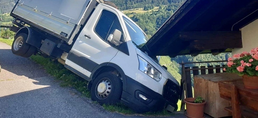 Esce di strada e si incastra nel tetto di un’abitazione: parabrezza sfondato e furgone in bilico