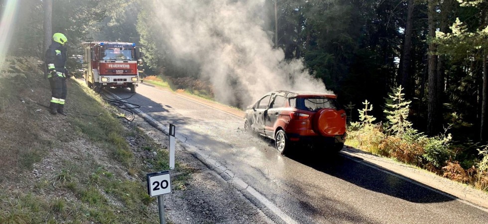 Un'auto distrutta dalle fiamme sulla carreggiata ed il rogo rischia di propagarsi al bosco: l'intervento dei pompieri