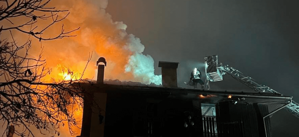 Fiamme altissime dalla canna fumaria e il tetto e l'ultimo piano di un edificio finiscono distrutti