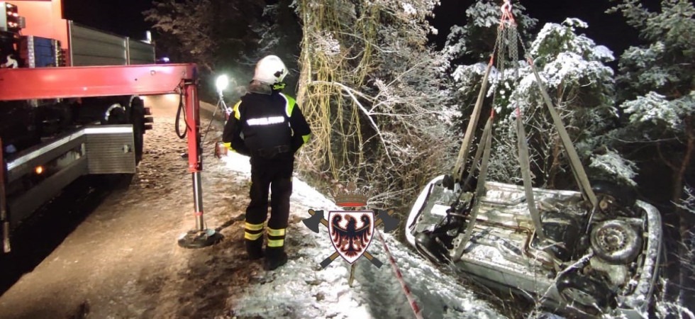 Foto Federazione dei vigili del fuoco volontari del Trentino Esce di strada con l'auto durante la nevicata e si ribalta in una scarpata: pompieri in azione con il braccio meccanico