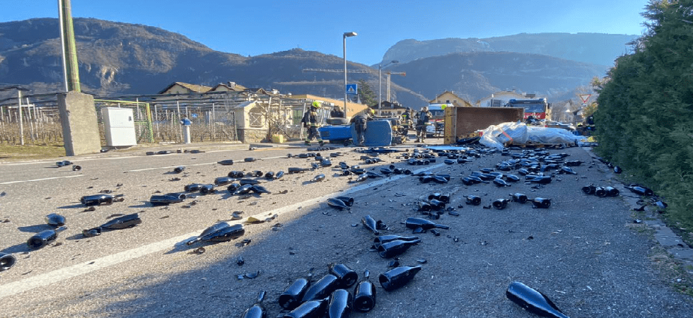 Trattore col rimorchio carico di bottiglie si ribalta: strada bloccata per il vetro sull'asfalto e in azione l'autogrù