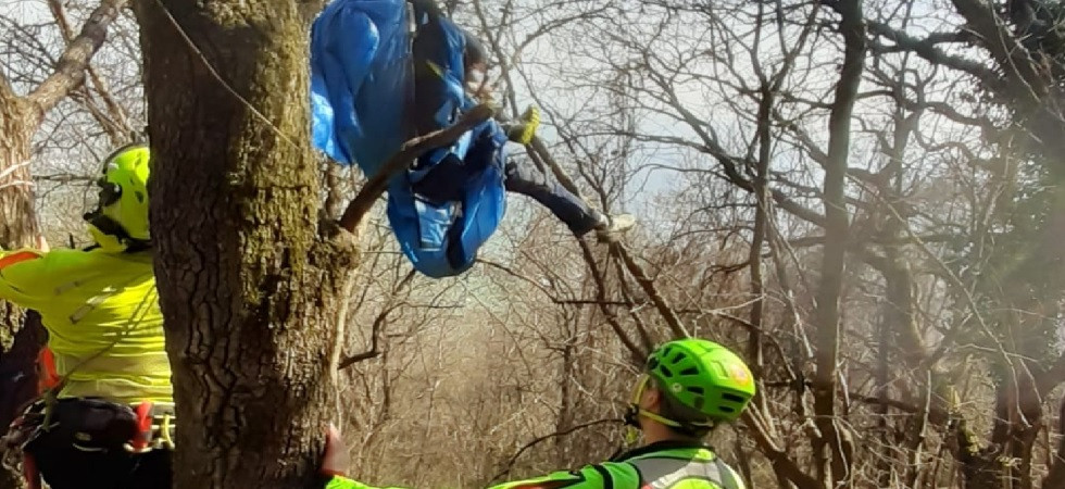 Sbaglia manovra e precipita con il parapendio, 26enne rimane bloccato fra i rami a 3 metri d'altezza