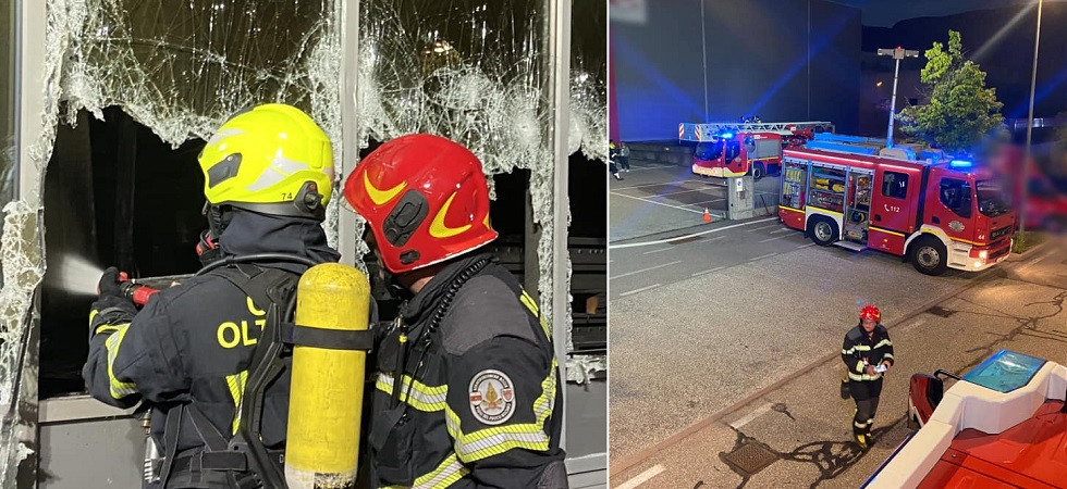 Fumo e fiamme all'interno di un magazzino, vigili del fuoco in azione nella notte