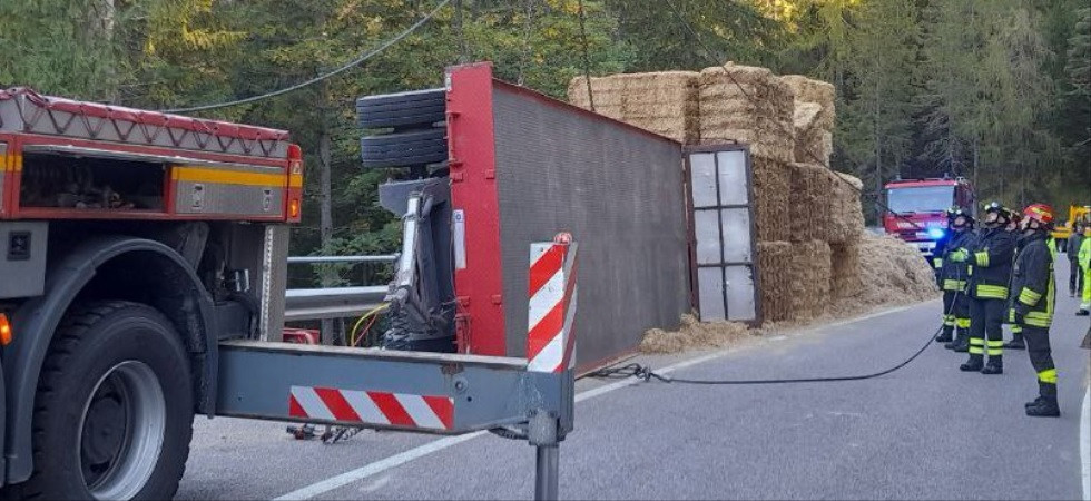 Perde il controllo del camion e il rimorchio carico di balle di fieno si ribalta, vigili del fuoco sul posto