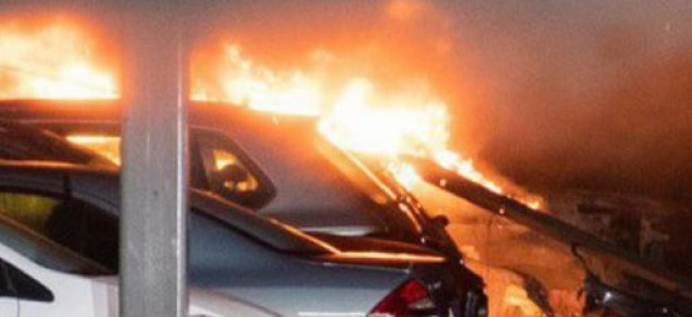 Foto d'archivio Fiamme divampano in un parcheggio e avvolgono 4 auto, i mezzi completamente distrutti