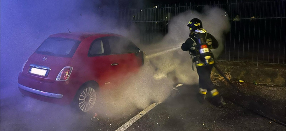 Auto in fiamme nella notte, il rogo davanti alla recinzione della piscina: vigili del fuoco in azione