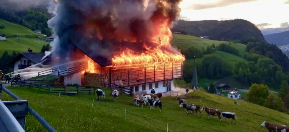 La colonna di fumo e le fiamme avvolgono e distruggono un fienile, grosso incendio in un maso