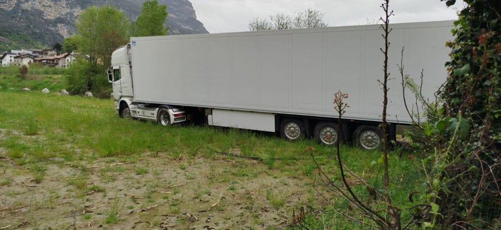 Si ferma alla strettoia e prova a girarsi nel campo: camion bloccato nel fango