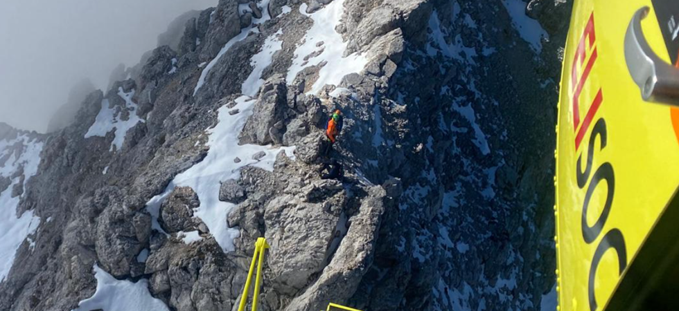Neve e ghiaccio ma due giovani vogliono scendere da una ferrata con scarpe da ginnastica
