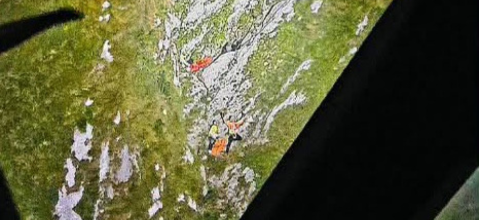 Vedono la flebile luce di un frontalino nel canalone buio e trovano un alpinista con la gamba rotta e il suo compagno di